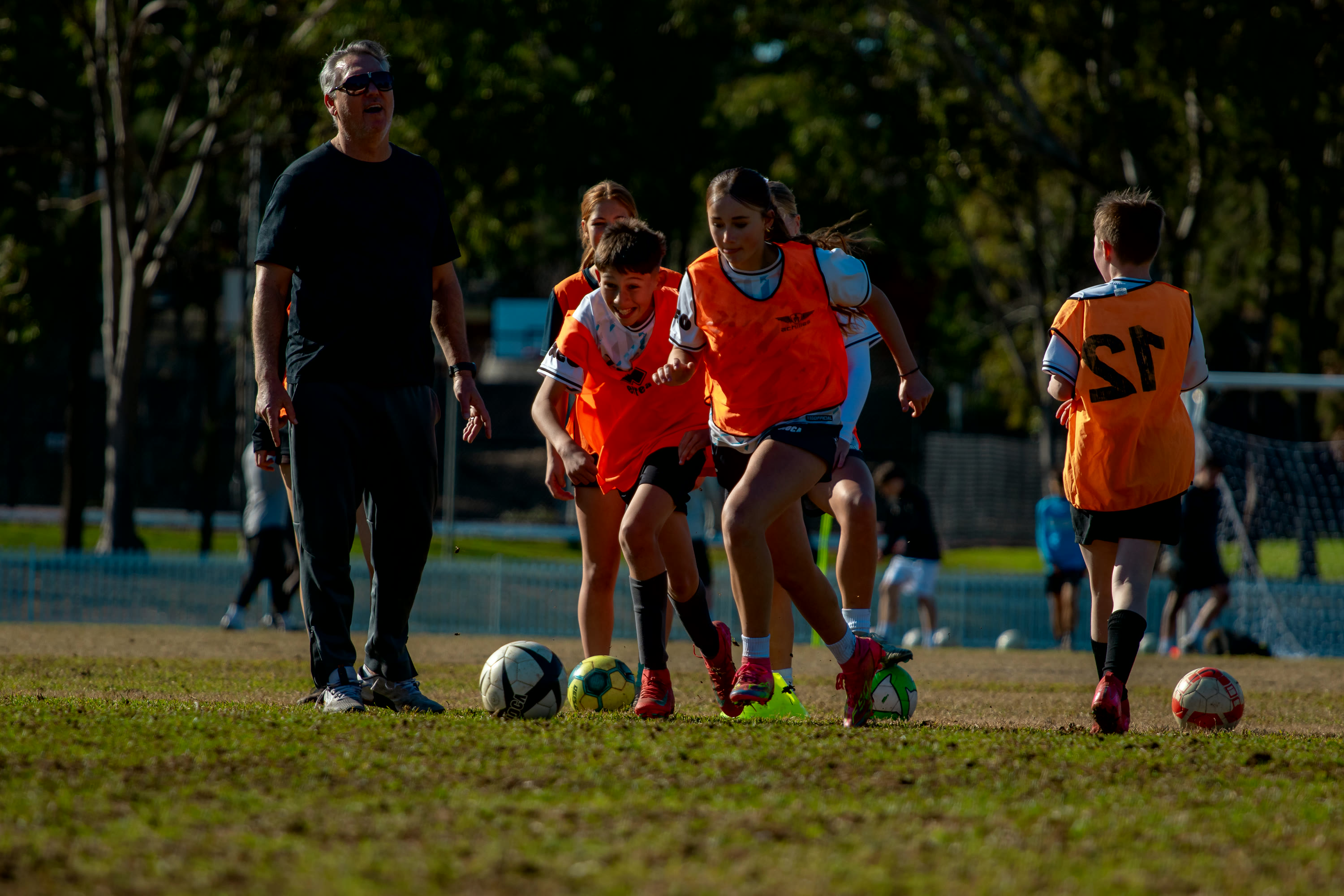 A Gamechanger coach leading a training session across the pitch.